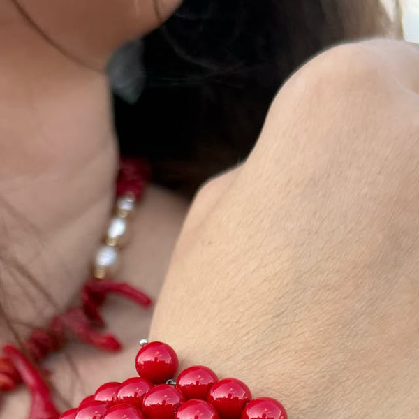 Red coral beaded bracelet worn on the wrist